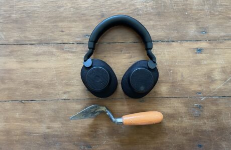 Image of a trowel and a pair of headphones on a wooden background